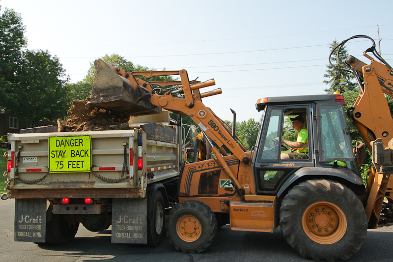 Street crews repaving a road with big machinery